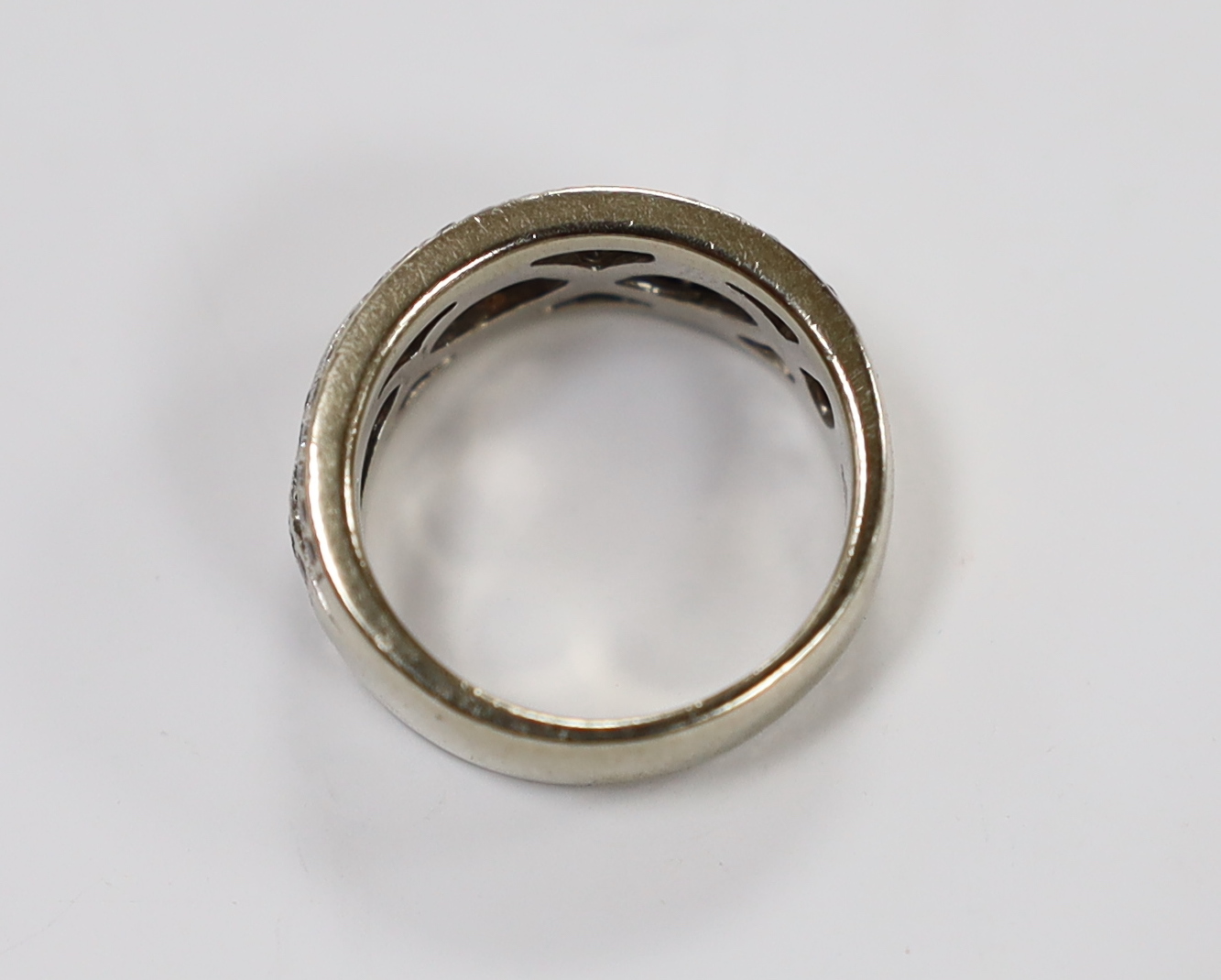 A modern 14ct white gold and diamond chip set spiral cluster ring with diamond set borders, size L, gross weight 7.2 grams.